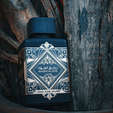 Lattafa Bade'e Al Oud For Glory EDP 100 мл – флакон върху дървесен фон